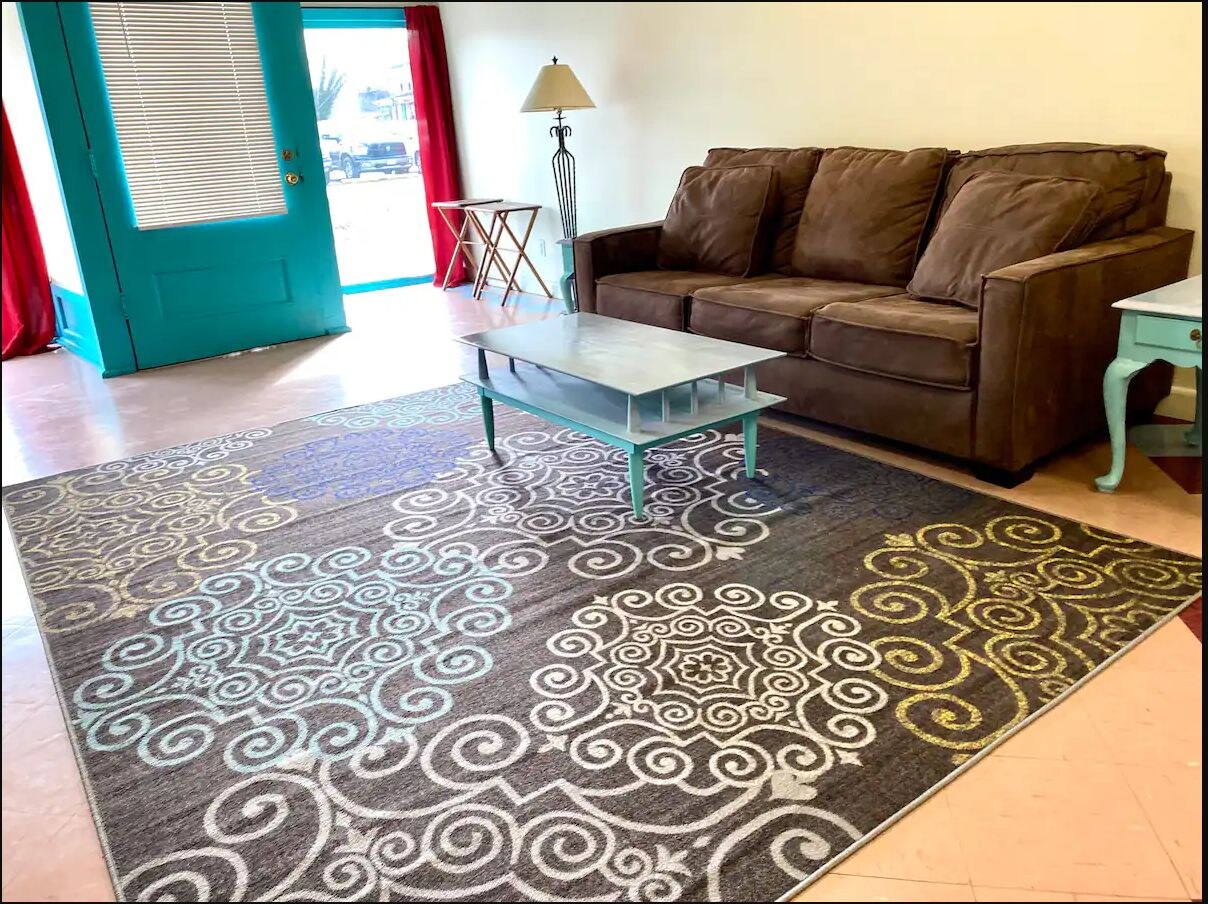 Colorful front living room with sofa and large patterned rug