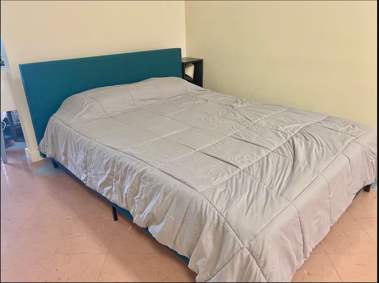 First bedroom with a queen bed and turquoise headboard