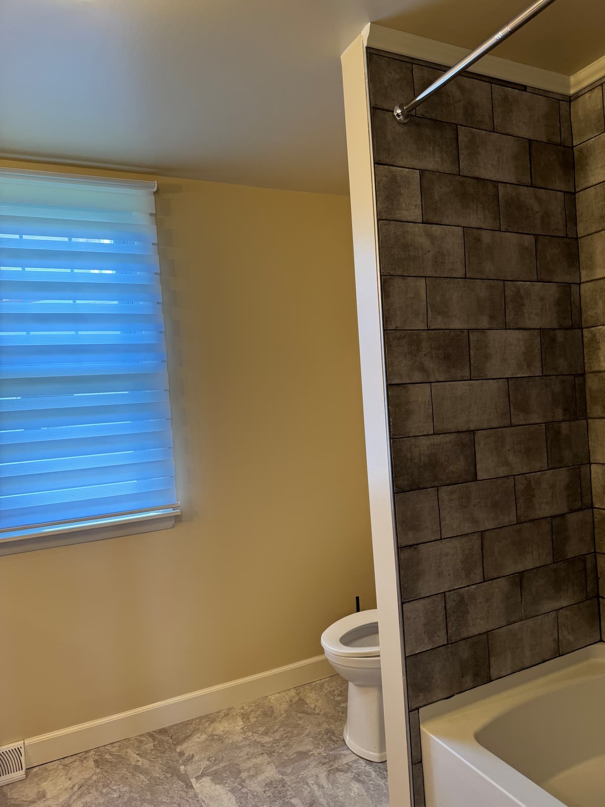 Bathroom with bathtub, tile surround and window