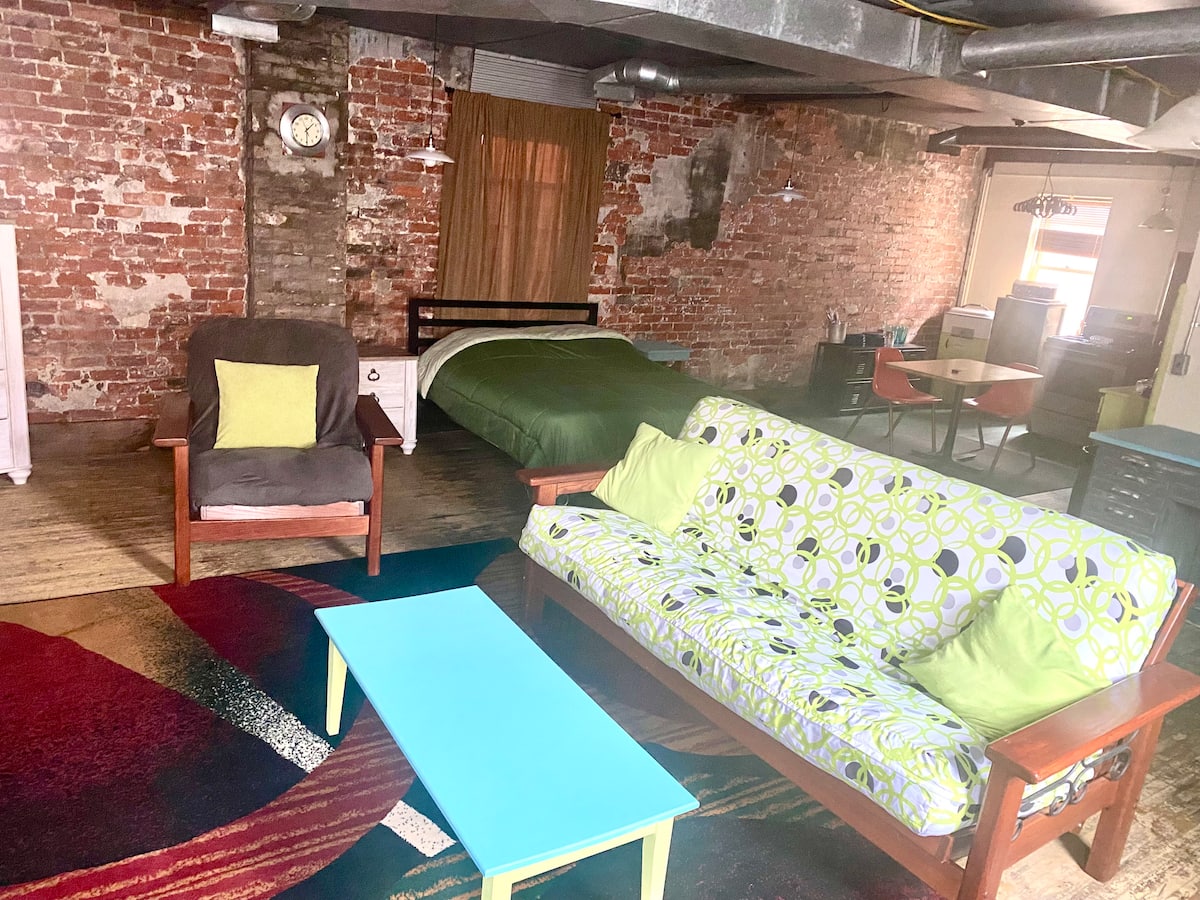 Rustic Apartment studio with exposed brick and colorful seating